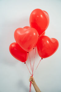 Close-up of hand holding red balloons
