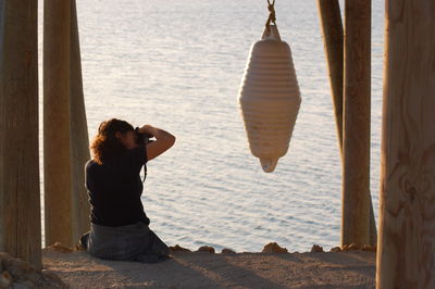 Rear view of woman photographing equipment