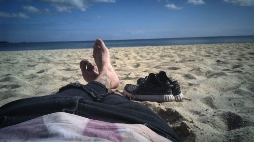 Low section of woman relaxing on beach