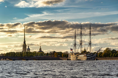 Sailboats in building against cloudy sky