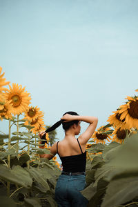 Low angle view of woman standing against cloudy sky