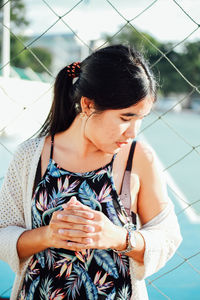 Young woman standing by net in court