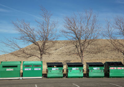 Recycle bins lined up outside.