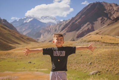 Full length of boy standing on arid landscape