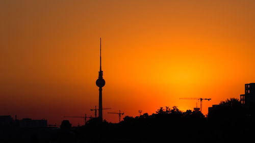 Silhouette of buildings against orange sky