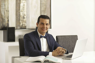Portrait of smiling man using laptop