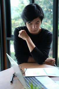 Man looking at camera while sitting on table