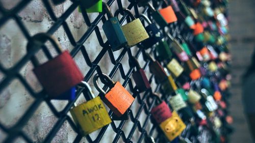 Close-up of padlocks on chainlink fence