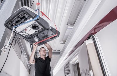 Low angle view of worker repairing motor home