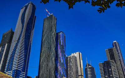 Low angle view of modern buildings against blue sky