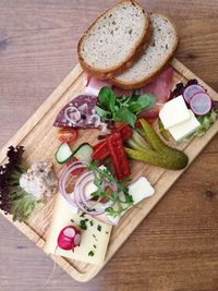 High angle view of bread and vegetables on wooden table