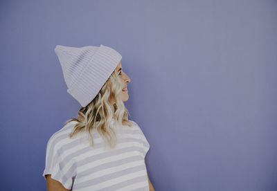 Rear view of woman wearing hat against wall