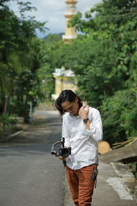 Full length of man photographing on footpath