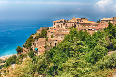 High angle view of townscape by sea against sky