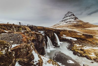 Scenic view of waterfall against sky during winter