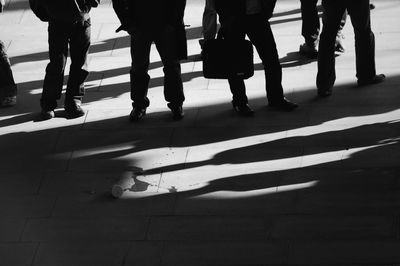 Low section of people standing on tiled floor