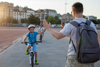 Rear view of people riding bicycles on street