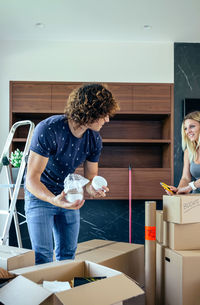 Woman with arms raised standing at home