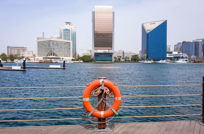 Fire hydrant by river against buildings in city