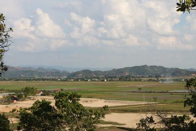 Scenic view of field against cloudy sky