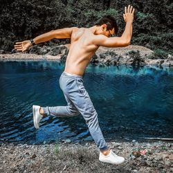 Full length of shirtless man standing in water