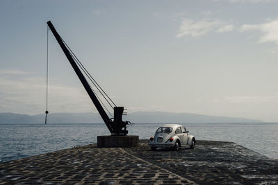 Volkswagon beetle on a pier by the ocean