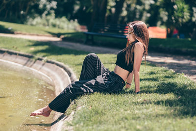 Woman sitting on field in park