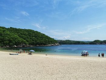 People at beach against sky