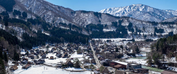 Panoramic view of snow covered trees and buildings in city