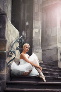 Full length of ballet sitting on steps