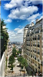 Buildings in city against cloudy sky