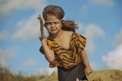 Portrait of young woman standing against sky