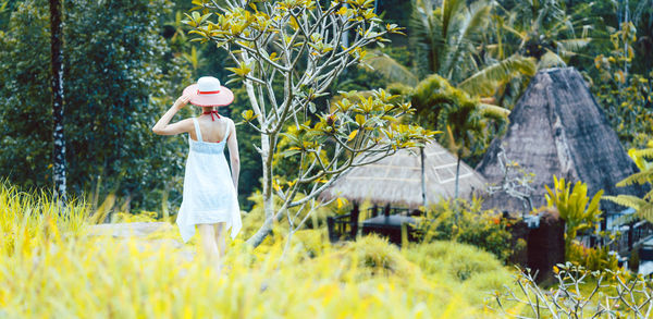 Rear view of woman standing on field