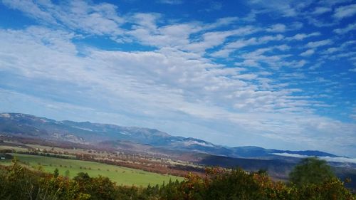 Scenic view of mountains against blue sky