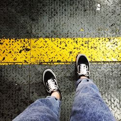 Low section of man standing on road