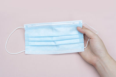 Close-up of hand holding paper over white background