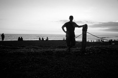 Silhouette people on beach against sky