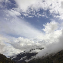 Low angle view of clouds over mountain against sky