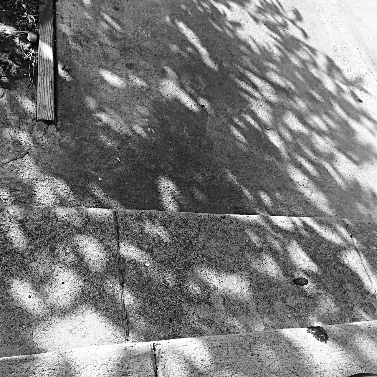 high angle view, textured, street, wall - building feature, shadow, sidewalk, sunlight, day, outdoors, cobblestone, paving stone, footpath, pattern, no people, built structure, full frame, architecture, wall, road, ground