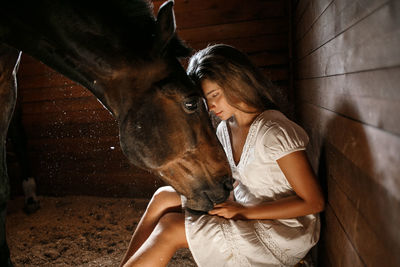 Woman stroking horse in stable