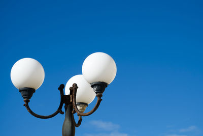 Low angle view of street light against blue sky