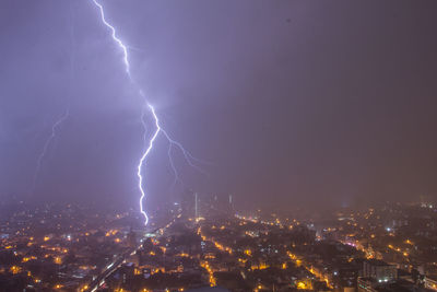 Lightning strike over night city lights