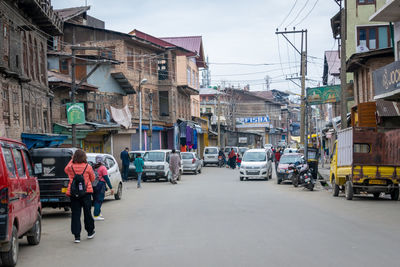 People on street amidst buildings in city