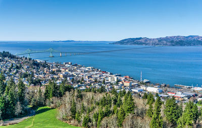 High angle view of city by sea against clear sky