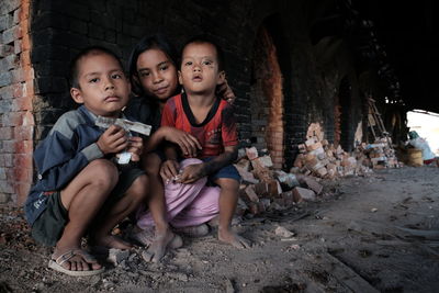 Portrait of siblings against brick wall