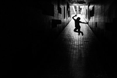 Silhouette man walking in corridor