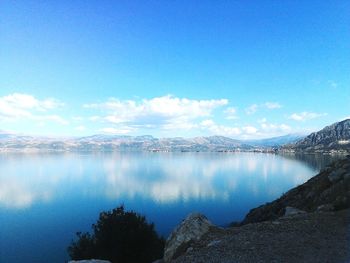 Scenic view of reflection of trees against blue sky