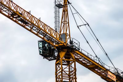 Low angle view of crane against sky