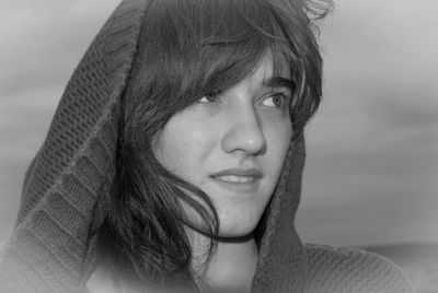 Close-up portrait of a smiling young woman looking away