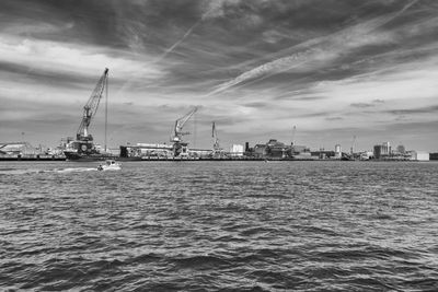 Commercial dock by sea against sky